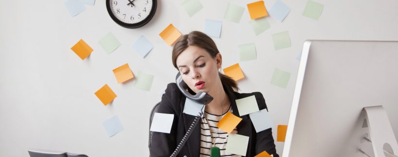 Studio shot of young woman working in office covered with adhesive notes