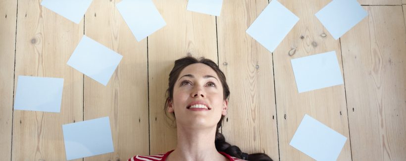 Woman surrounded by blank sheets of paper