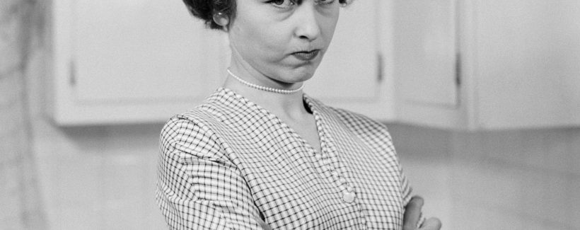 UNITED STATES - CIRCA 1950s:  Housewife in kitchen, arms folded, with serious expression.  (Photo by H. Armstrong Roberts/Retrofile/Getty Images)